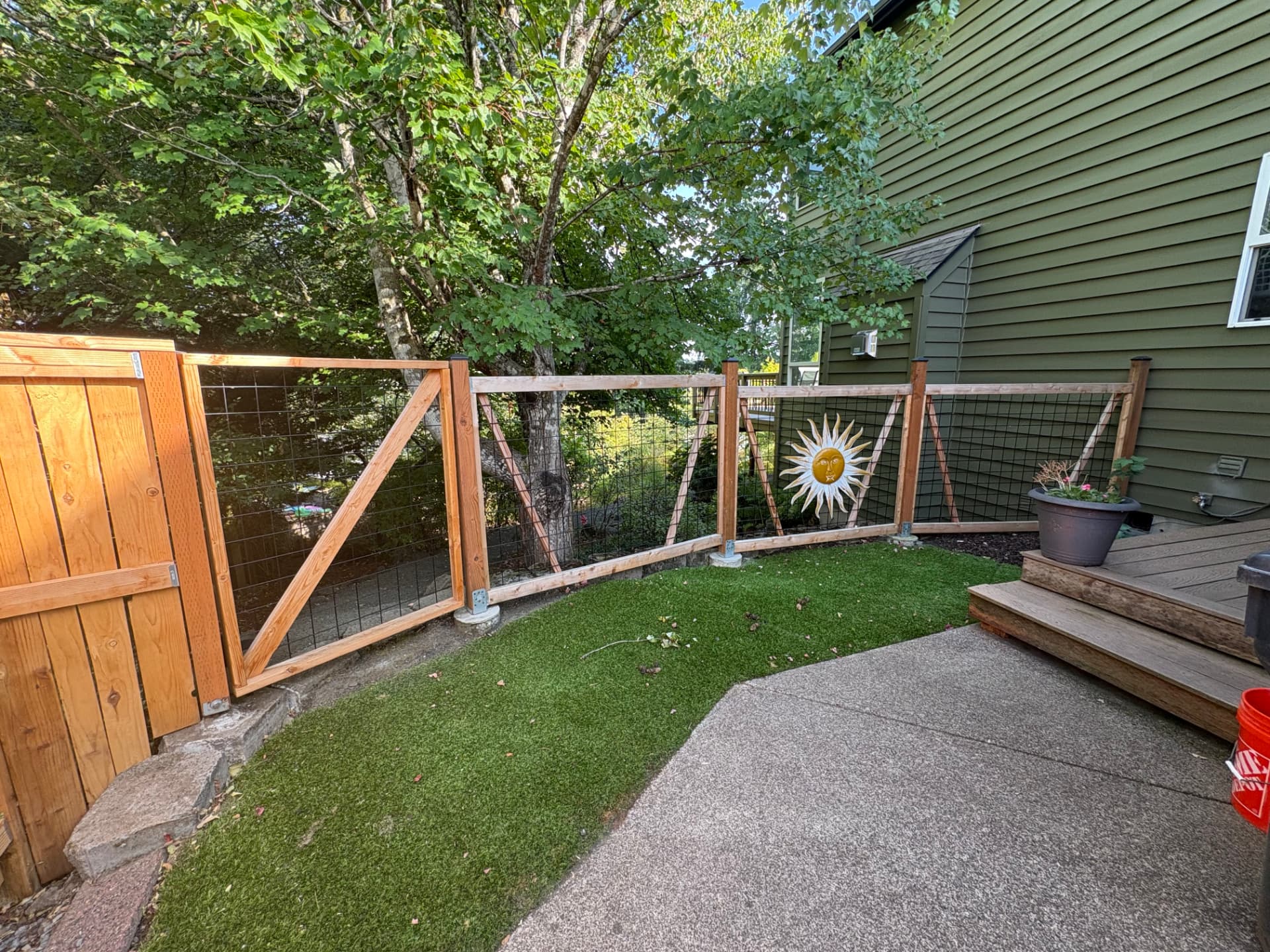 Cedar framed wire mesh fence and gate around a turf backyard